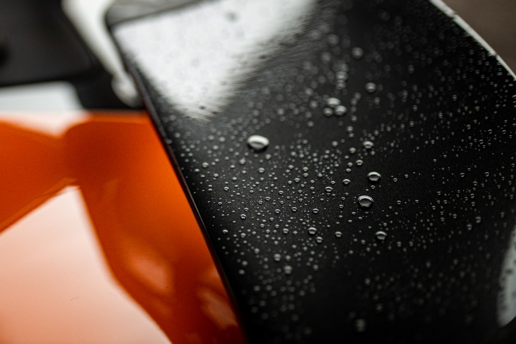 Raindrop-covered carbon fiber detail on orange McLaren bodywork
